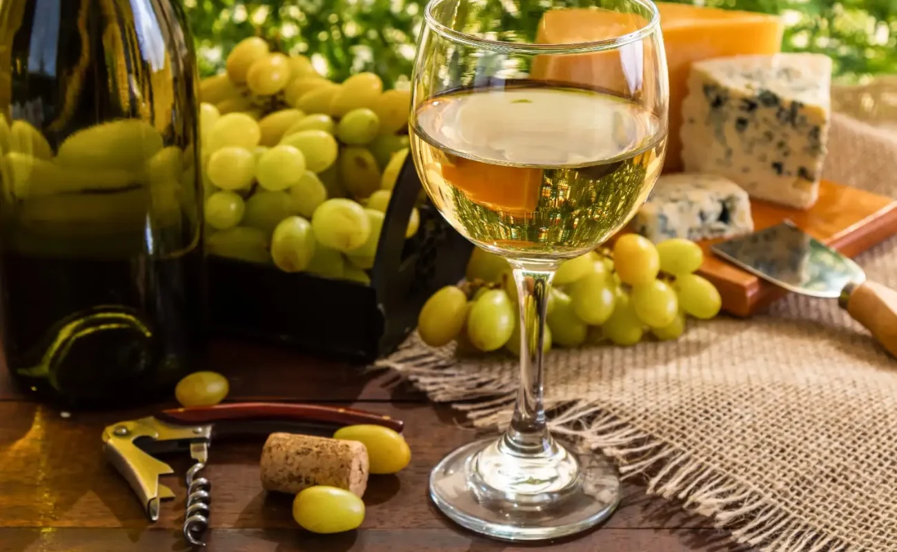 white wine on table with cheese grapes